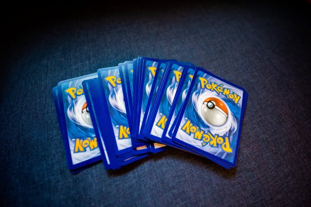 A collection of Pokemon trading cards laid out on a dark surface, showcasing their distinct back designs.